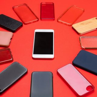 wybor wielokolorowych plastikowych tylnych oslon na telefony komorkowe na czerwonym tle ze smartfonem z boku